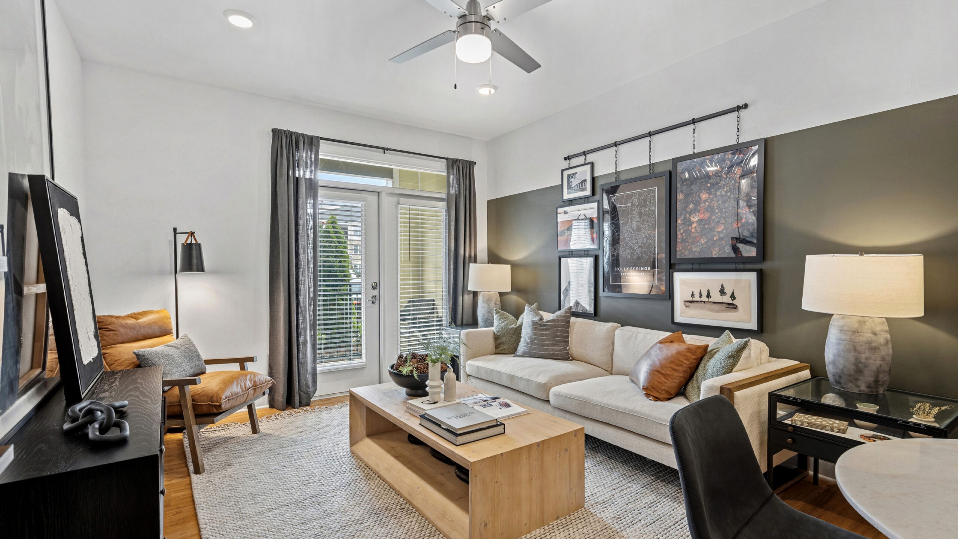 Hawthorne at Holly Springs luxury Holly Springs, NC apartment living space with spacious living room looking towards a beautiful kitchen with an island and stainless steel appliances